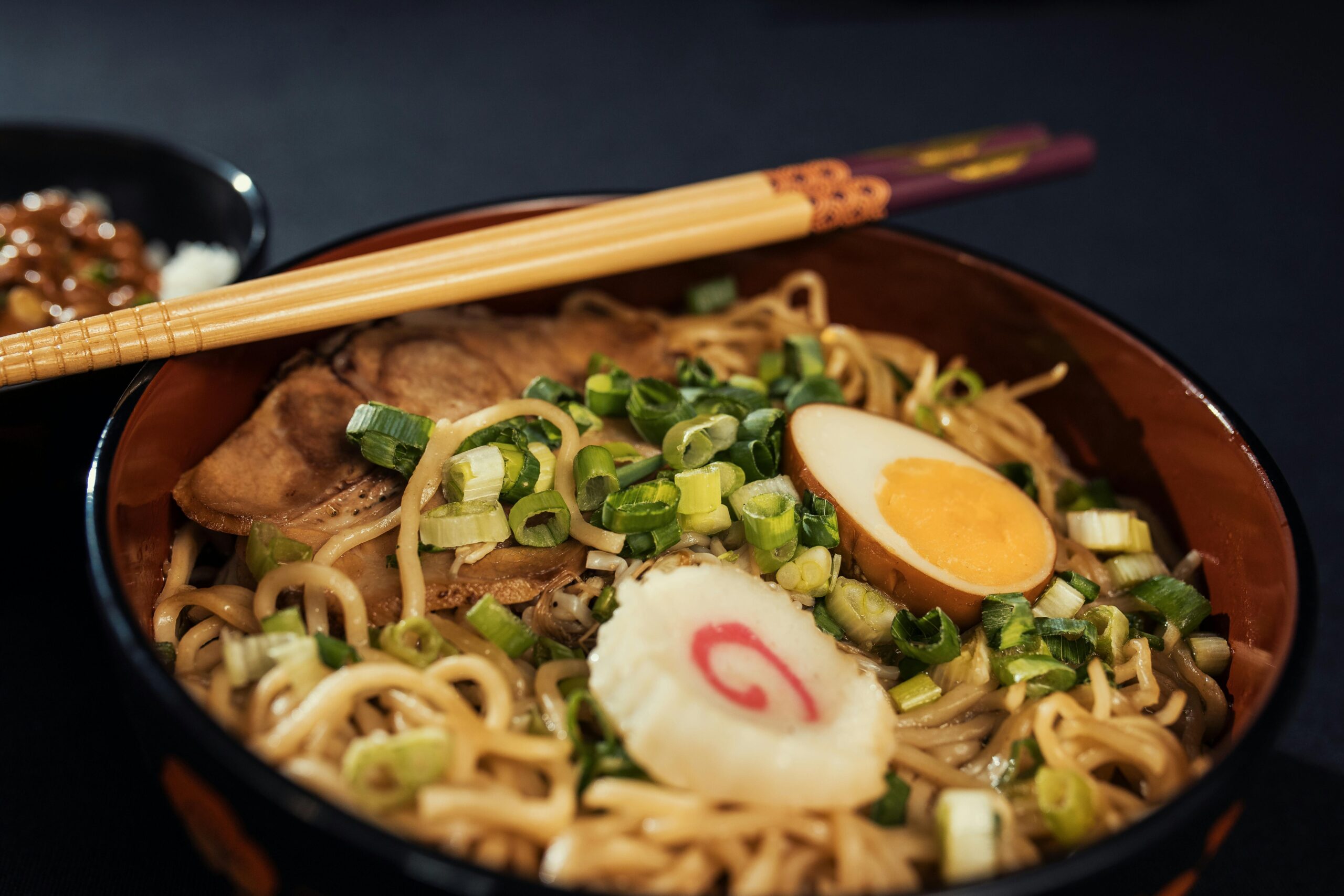 Ramen japonés servido con fideos, huevo suave y caldo tonkotsu en tazón tradicional.