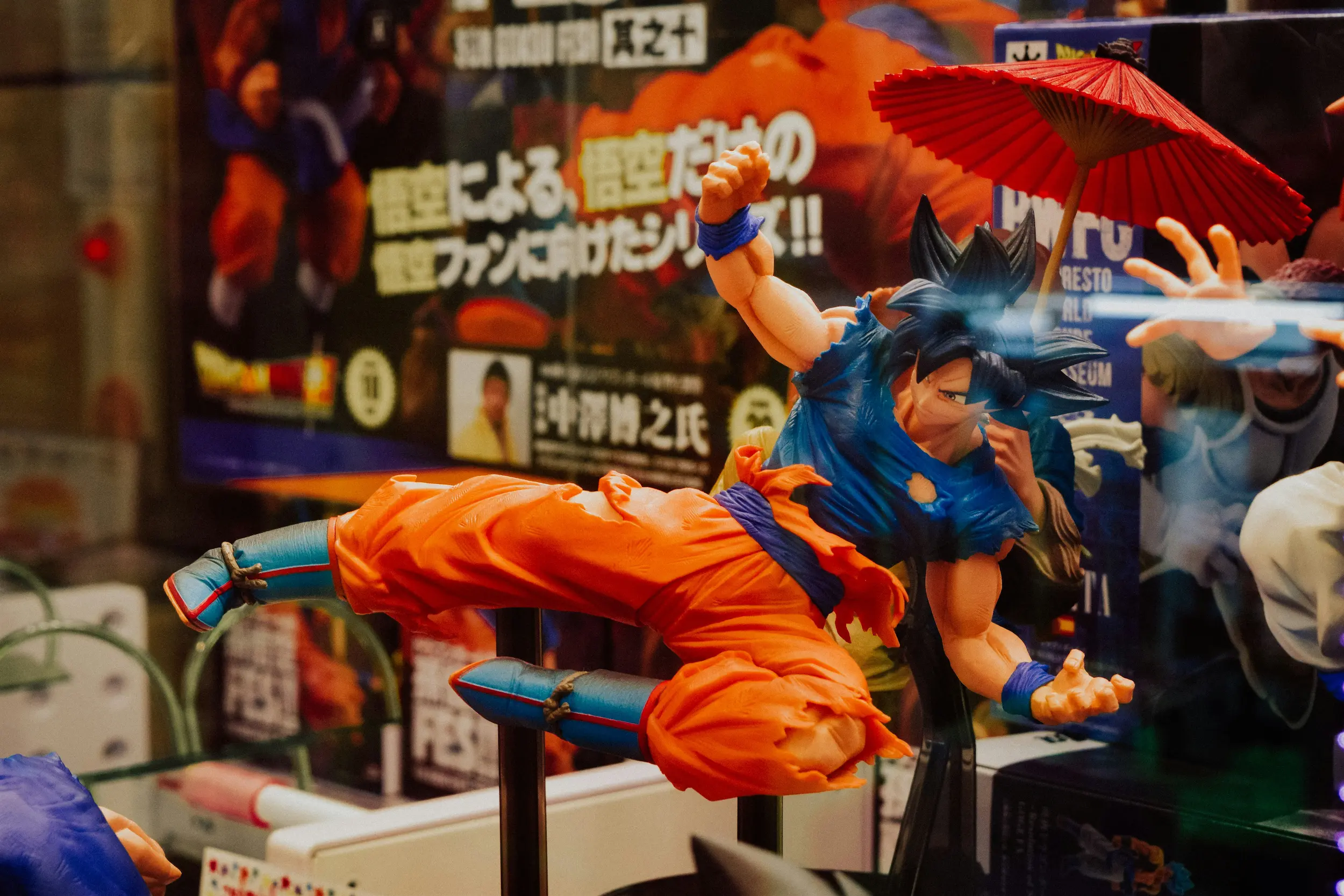 Tienda de figuras de Dragon Ball en Akihabara, Tokio, con exhibidores llenos de estatuas de Goku, Vegeta, Freezer y todos los personajes de la serie en diferentes escalas.