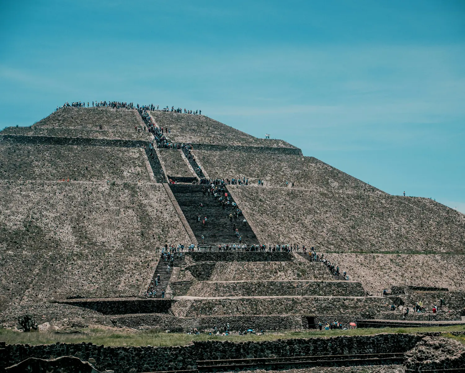 Pirámide del Sol en Teotihuacán con visitantes subiendo por las escalinatas en un día despejado, Estado de México