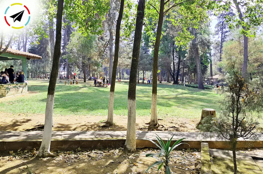 Vista panorámica del Parque La Pínera en Uruapan, espacio público familiar con su kiosko central y áreas verdes.