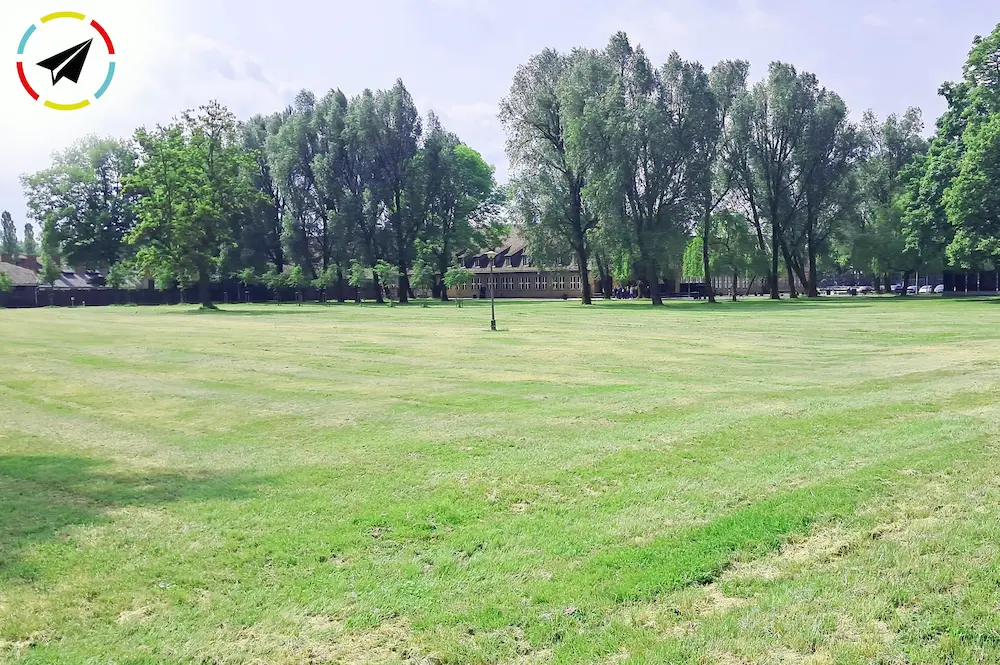 Entrada al campo de concentración de Auschwitz, césped verde y vegetación.