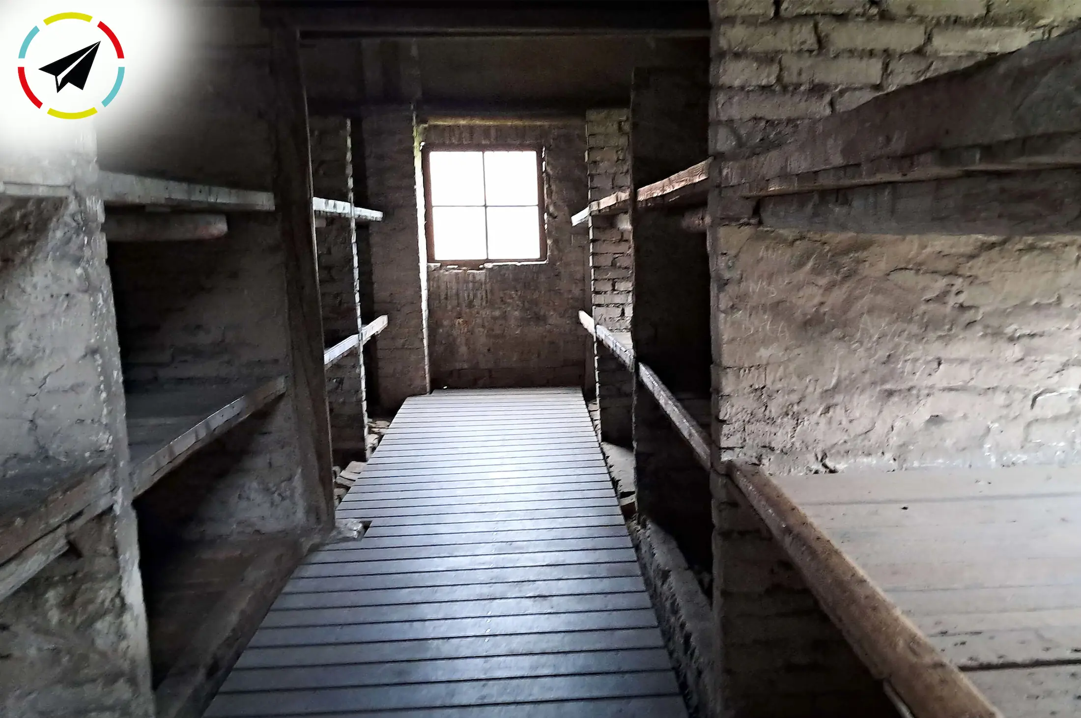 Hileras de literas de madera de tres niveles alineadas en un barracón de Auschwitz, mostrando el hacinamiento extremo donde cientos de prisioneros dormían pegados unos contra otros.