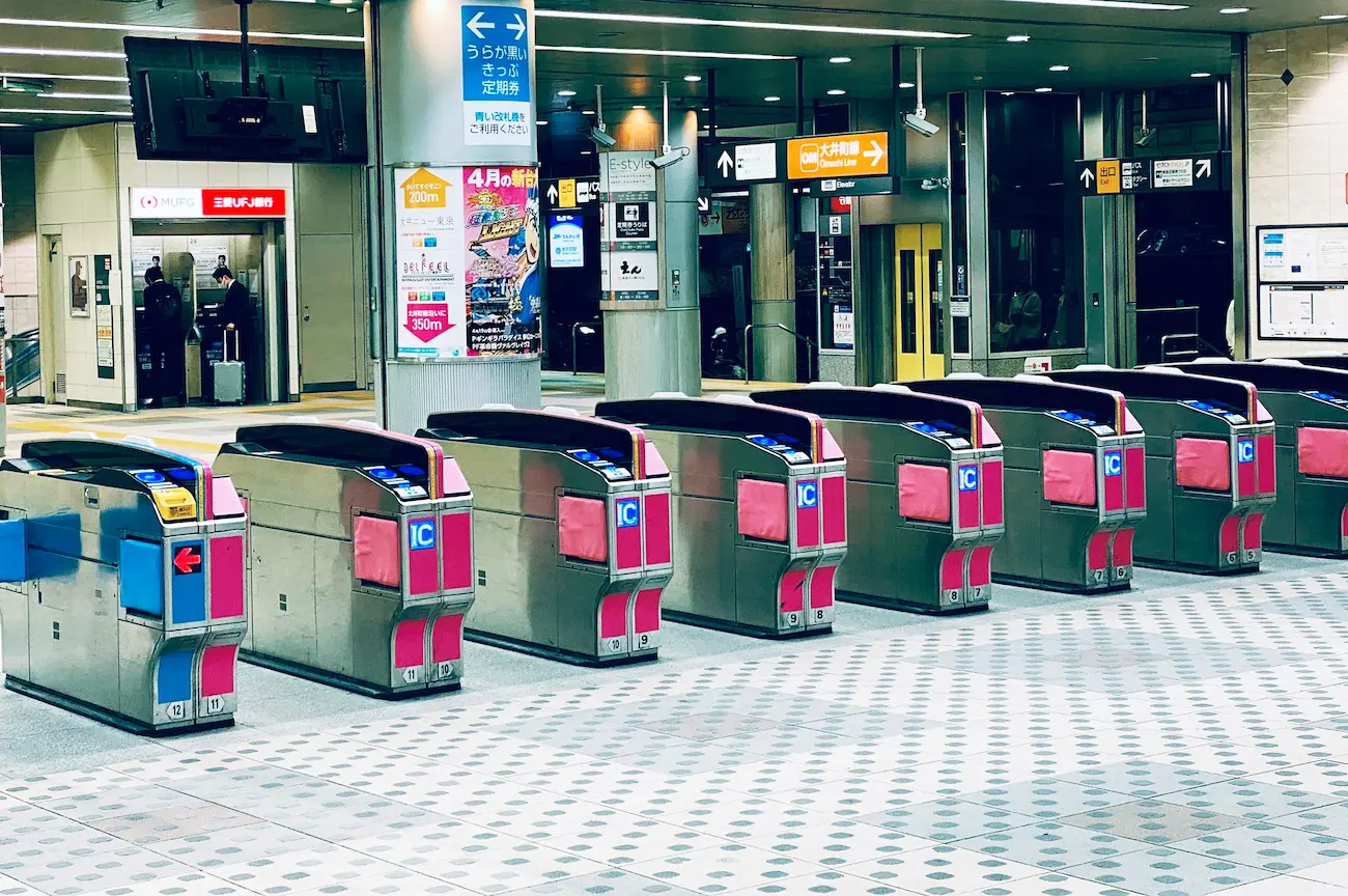 Torniquete automático de una estación de tren en Japón con el lector naranja y azul de Suica, donde los pasajeros tocan su tarjeta para entrar o salir del andén