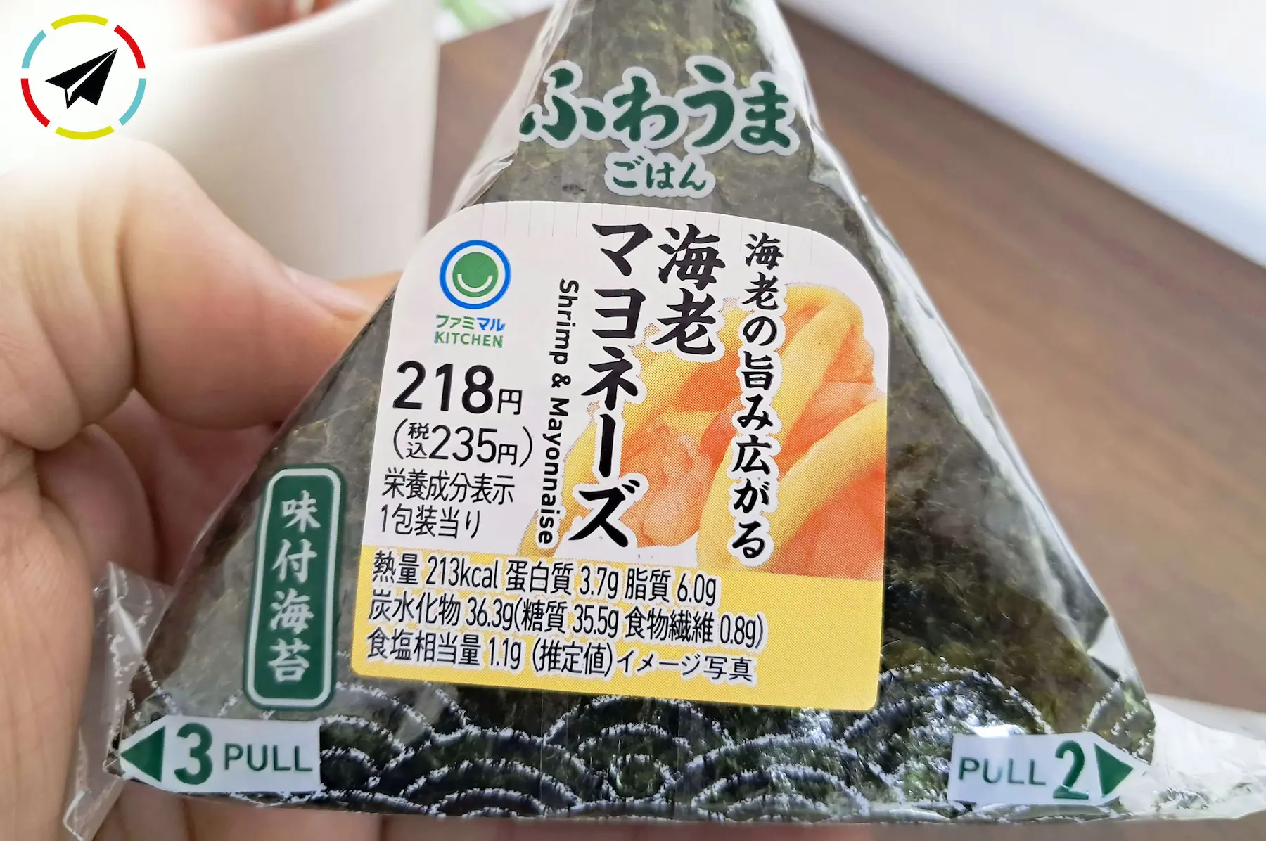 sosteniendo un onigiri recién comprado de un konbini japonés, con el envoltorio y el alga nori crujiente visible.